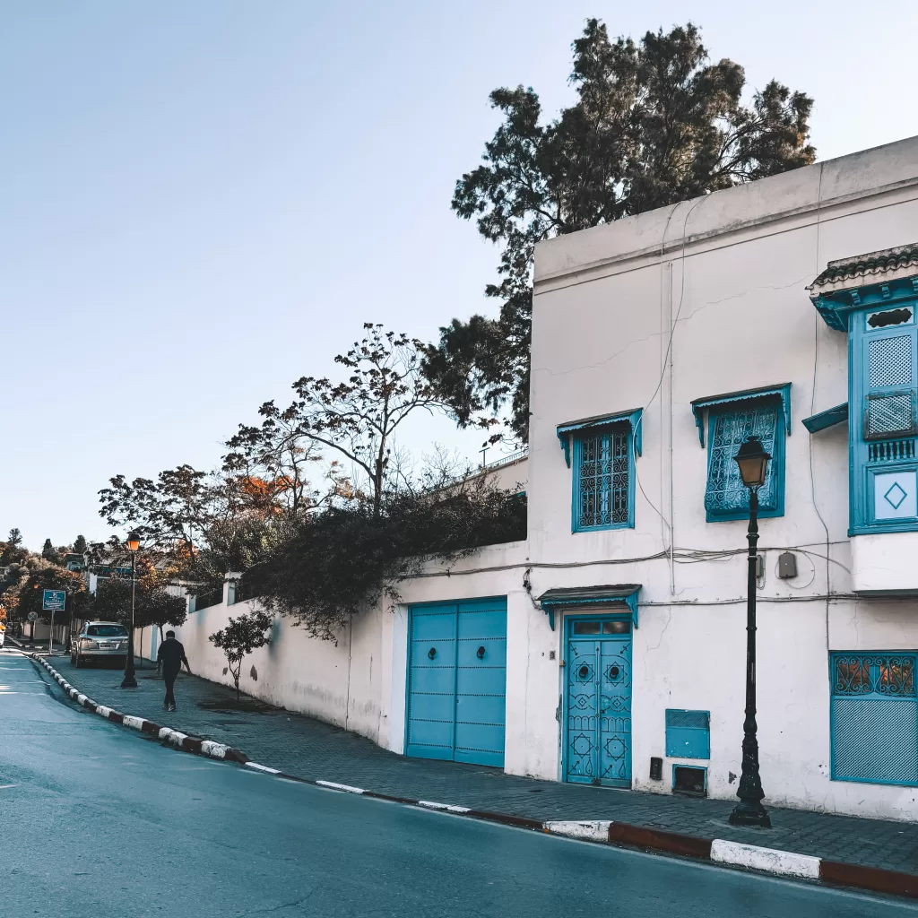 A Sidi Bou Said street with a white building and turquoise blue window frames and doors